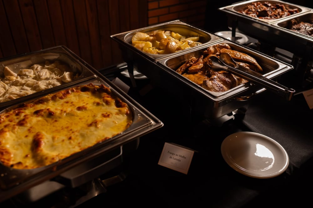 Rechauds com massas e carnes no serviço do buffet